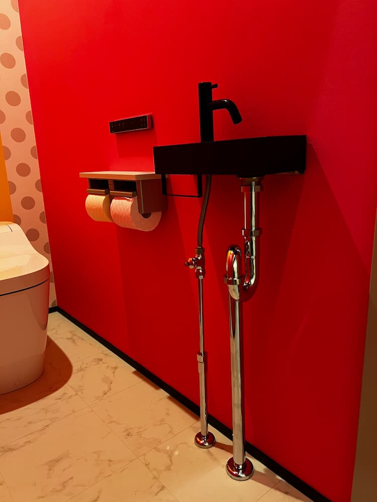 赤いアクセントクロスを使ったトイレ空間の写真